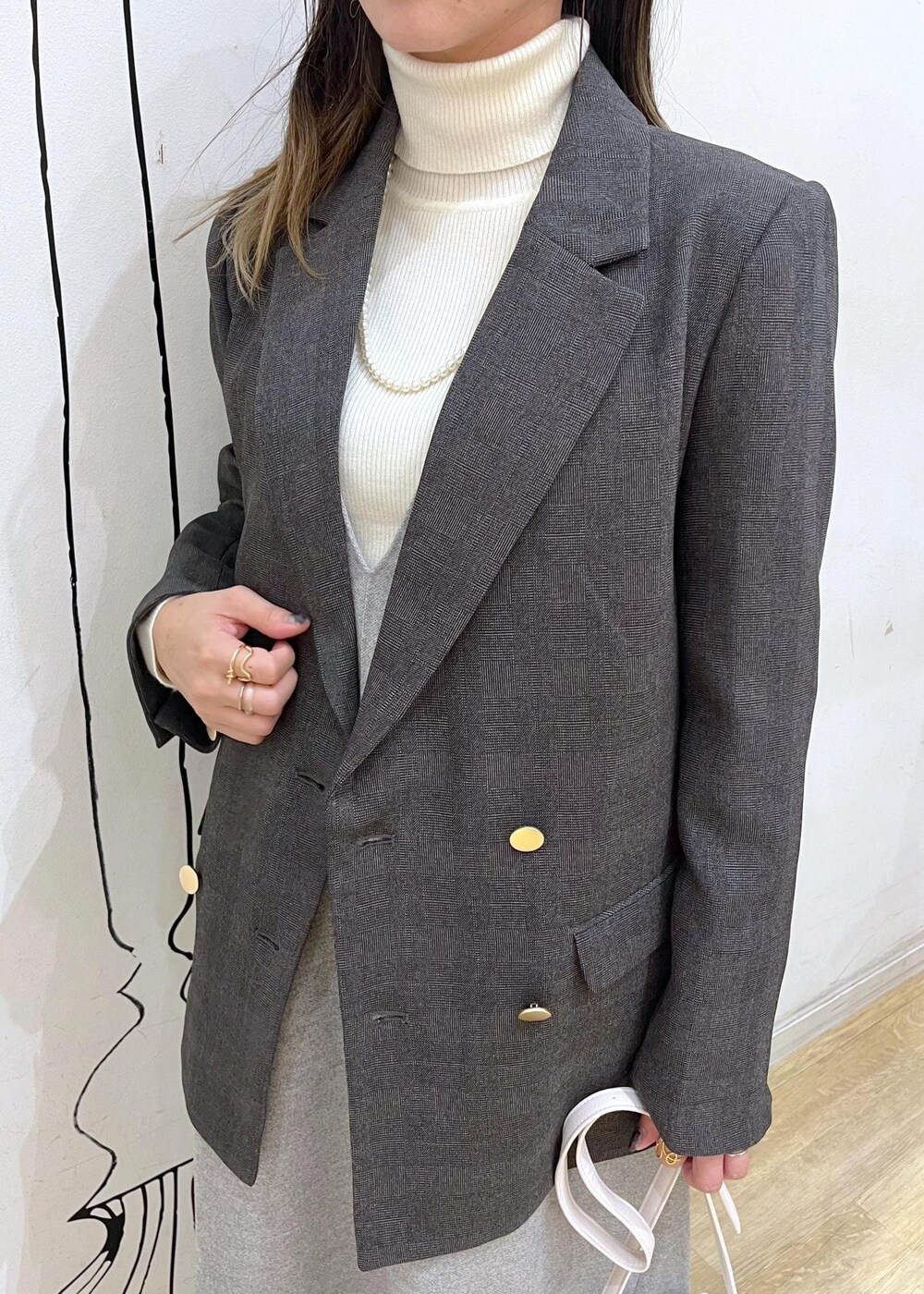 ホワイト系のショルダーバッグ、ブラック系のブーツ、ホワイト系のニット/セーターを着用したレディースの冬コーディネートの6枚目の写真