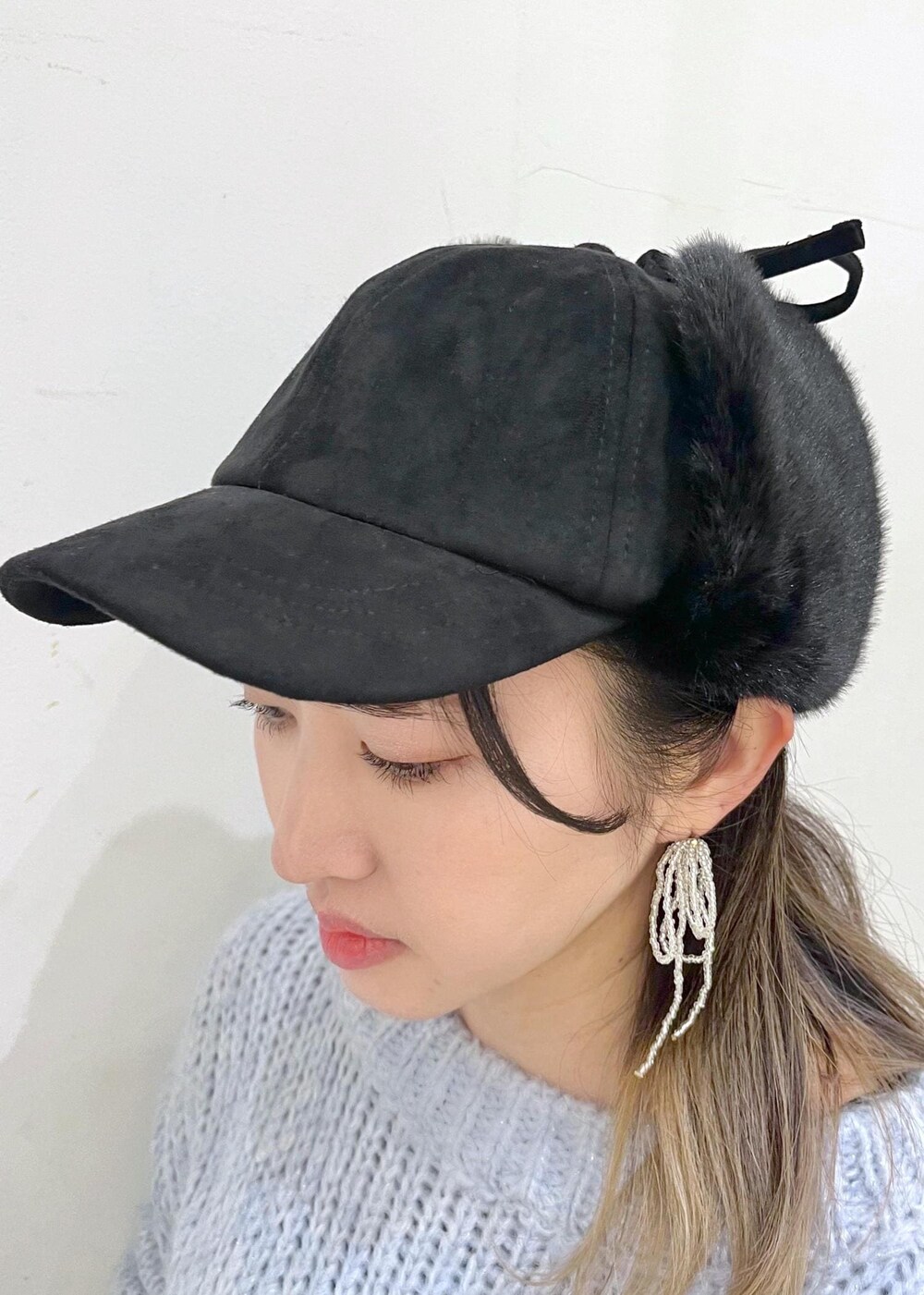 ブラック系のニット/セーター、ブラック系のブーツ、ブラック系のボストンバッグを着用したレディースの冬コーディネートの6枚目の写真