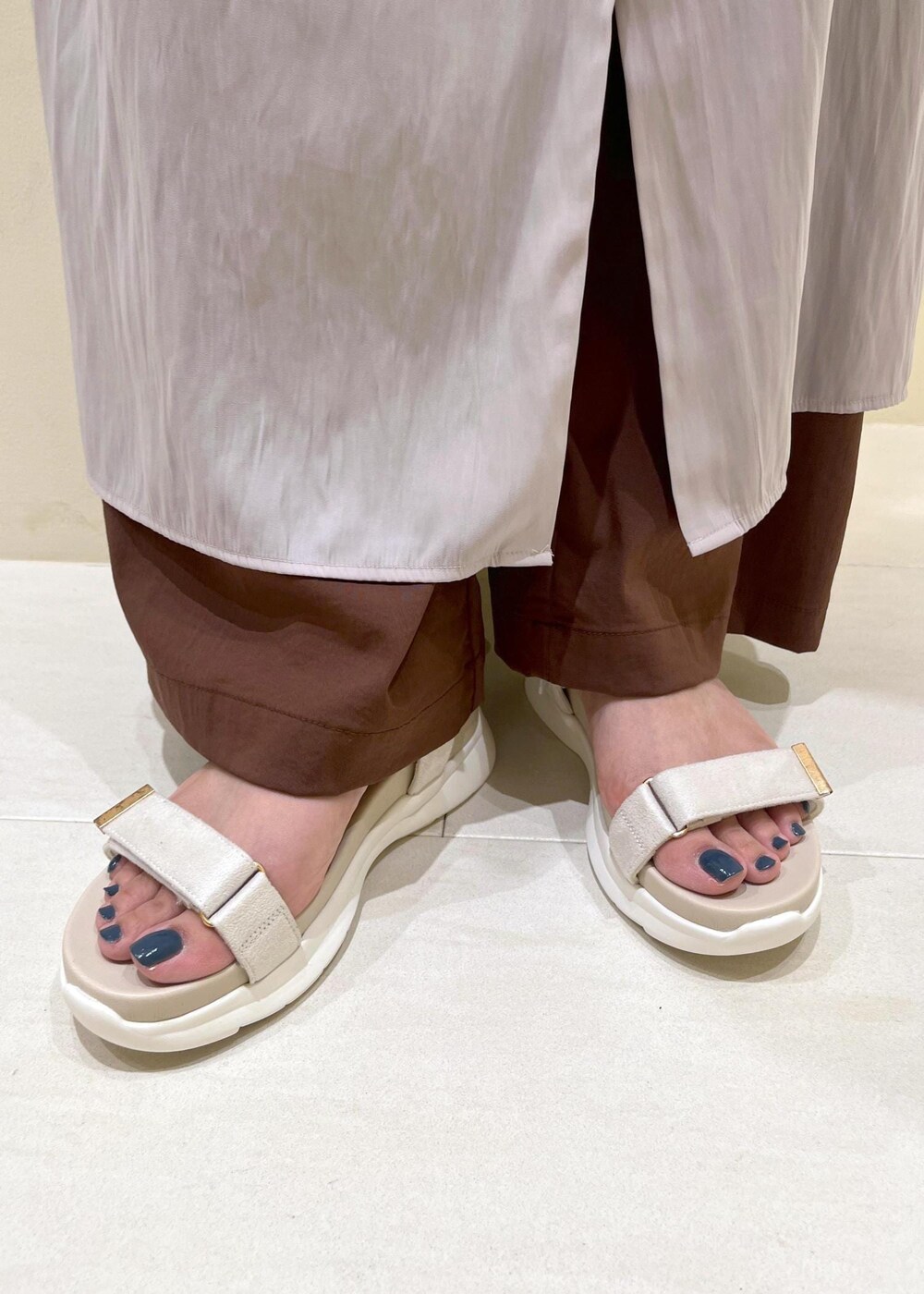 ベージュ系のワンピース、ブラウン系のその他パンツ、ホワイト系のサンダルを着用したレディースの春コーディネートの10枚目の写真