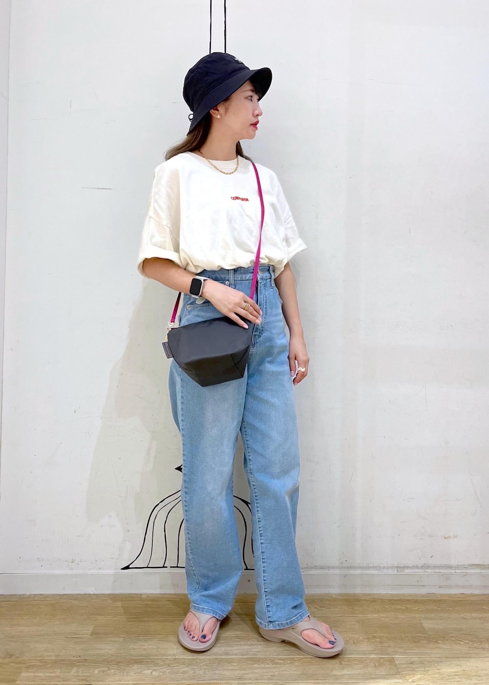 ホワイト系のTシャツ/カットソー、ブルー系のデニムパンツ、グレー系のショルダーバッグを着用したレディースの夏コーディネートの2枚目の写真