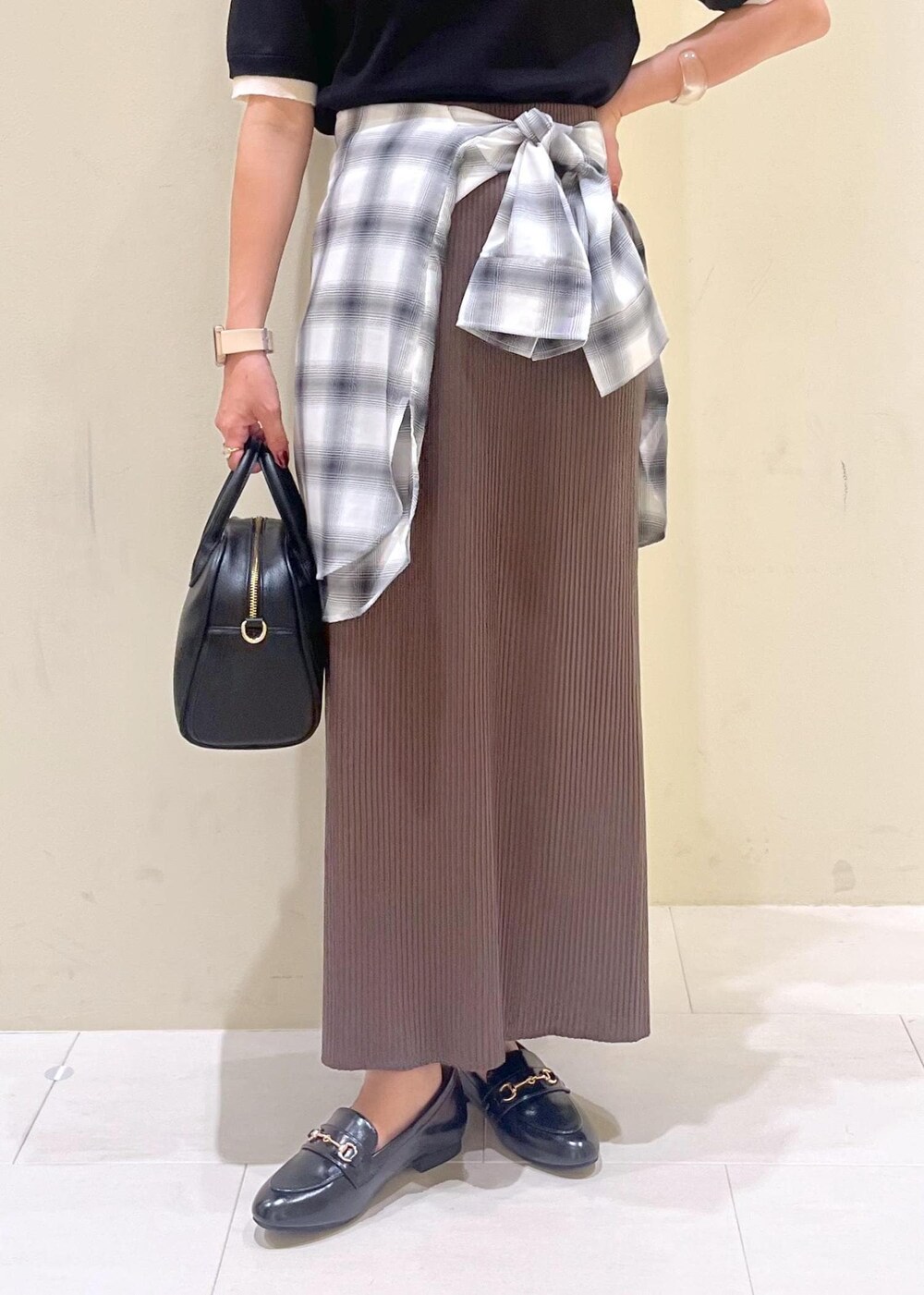 ブラック系のスカート、ブラック系のボストンバッグ、ブラック系のポロシャツを着用したレディースの夏コーディネートの8枚目の写真