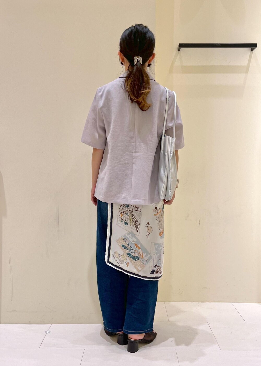 ブルー系のデニムパンツ、シルバー系のトートバッグ、ブラック系のパンプスを着用したレディースの夏コーディネートの3枚目の写真