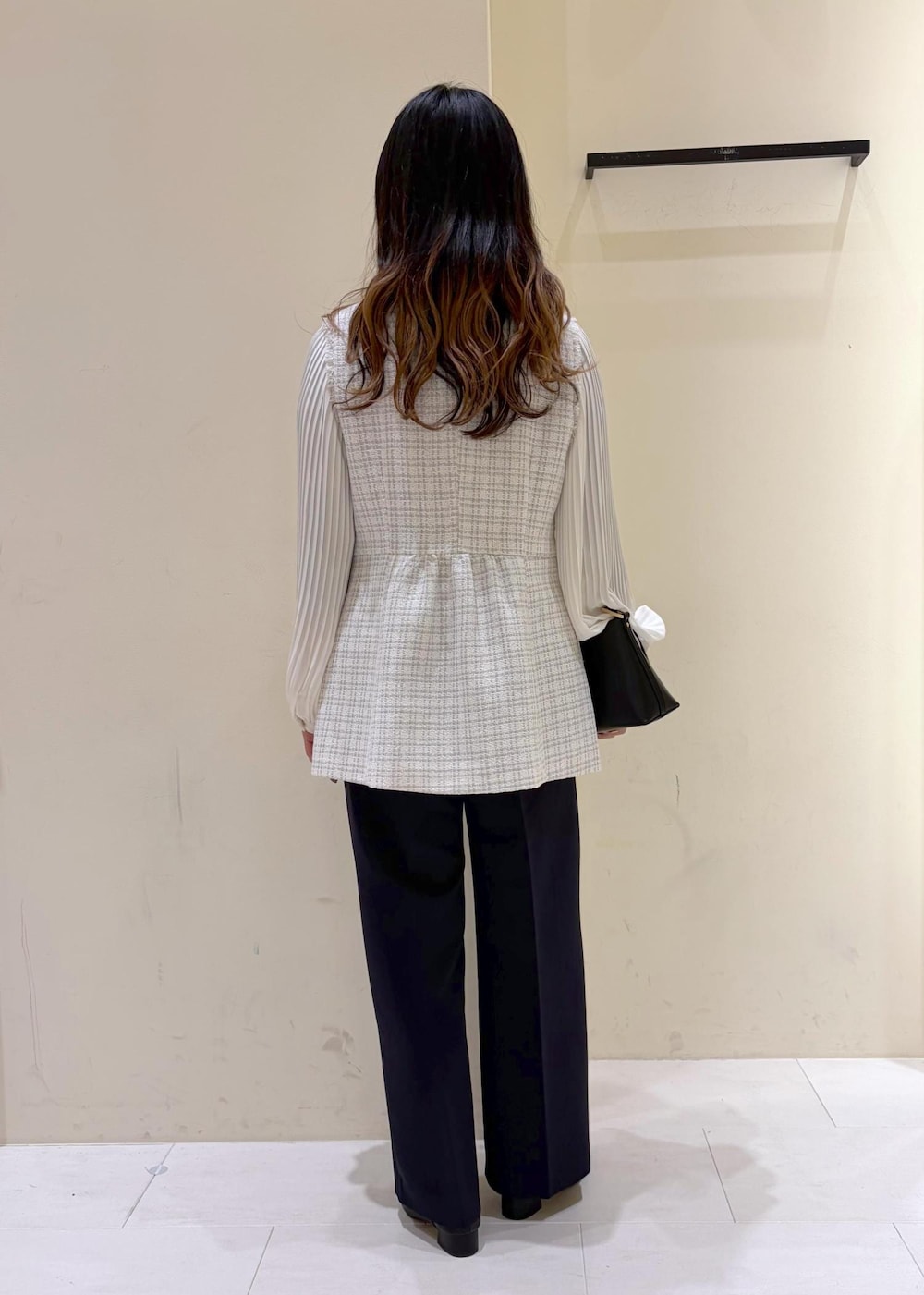 ブラック系のショルダーバッグ、ブルー系のその他パンツ、グレー系のベストを着用したレディースの冬コーディネートの3枚目の写真