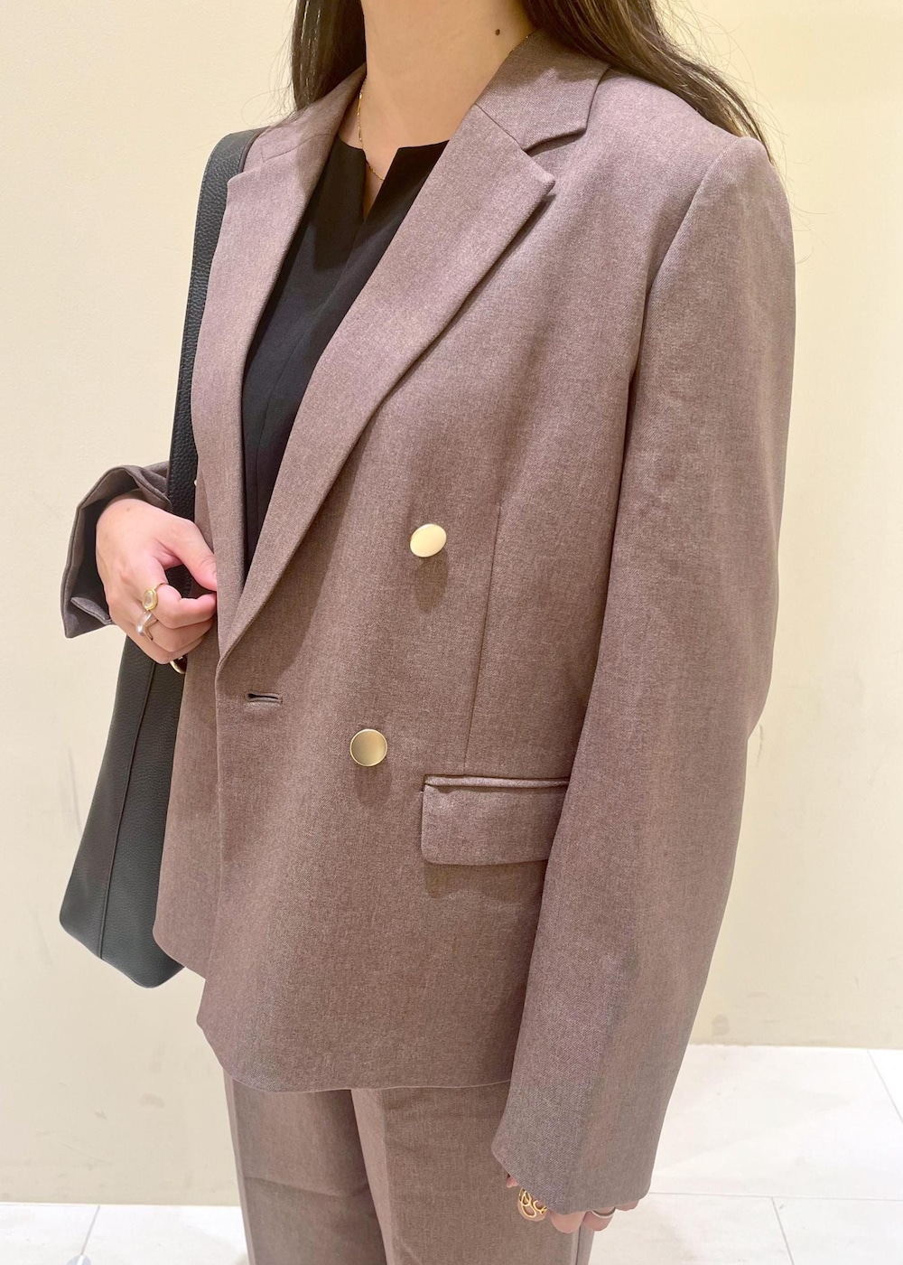 ブラック系のショルダーバッグ、ブラック系のシャツ/ブラウス、ベージュ系のテーラードジャケットを着用したレディースの秋コーディネートの5枚目の写真