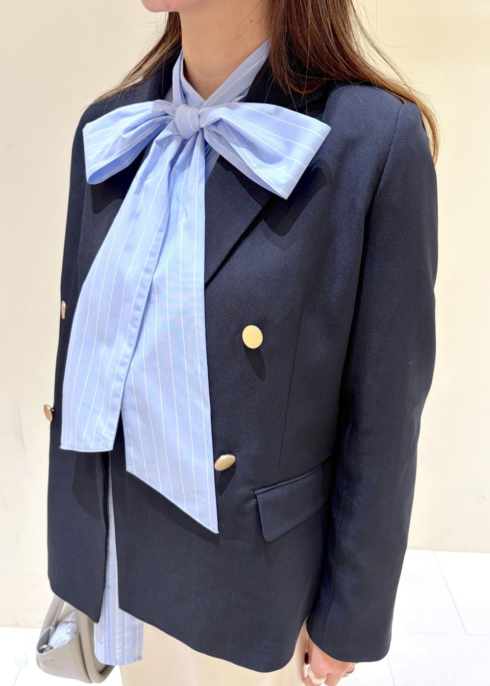 シルバー系のショルダーバッグ、ブルー系のテーラードジャケット、ブルー系のシャツ/ブラウスを着用したレディースの冬コーディネートの5枚目の写真