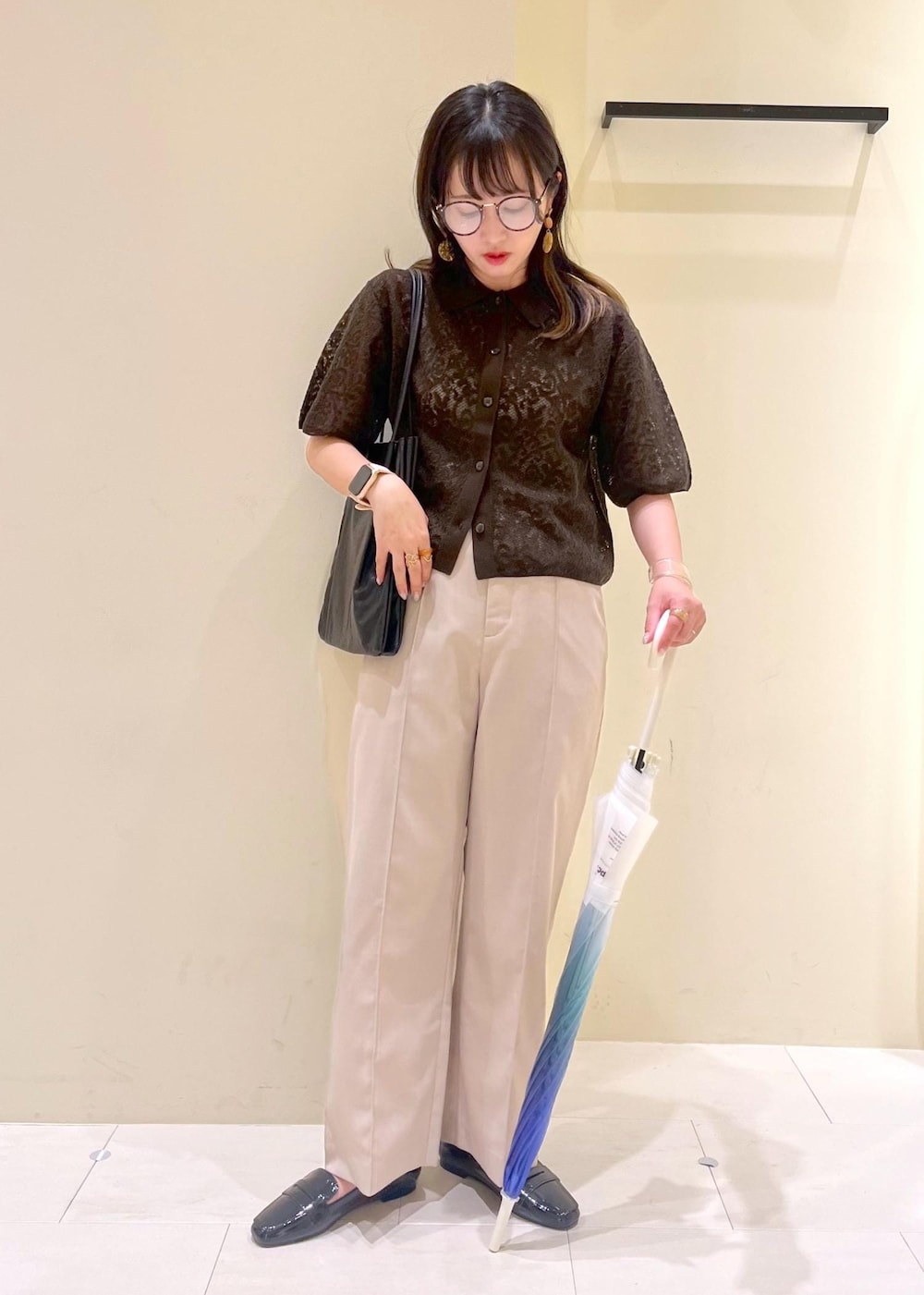 ブラック系のレインシューズ、ブラック系のトートバッグ、ベージュ系のその他パンツを着用したレディースの夏コーディネートの2枚目の写真