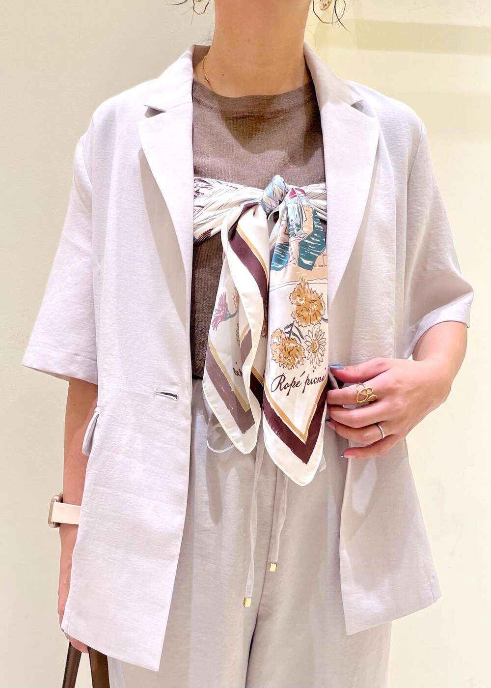 ベージュ系のテーラードジャケット、その他のニット/セーター、ブラウン系のショルダーバッグを着用したレディースの秋コーディネートの5枚目の写真