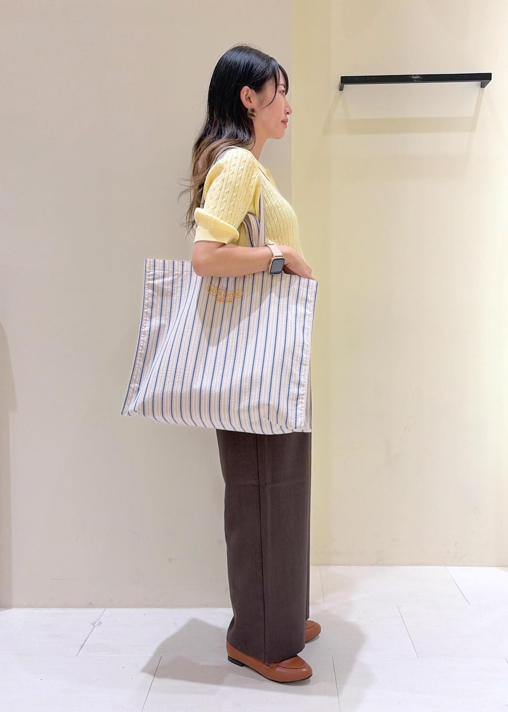 イエロー系のローファー、ブルー系のトートバッグ、ベージュ系のニット/セーターを着用したレディースの春コーディネートの4枚目の写真