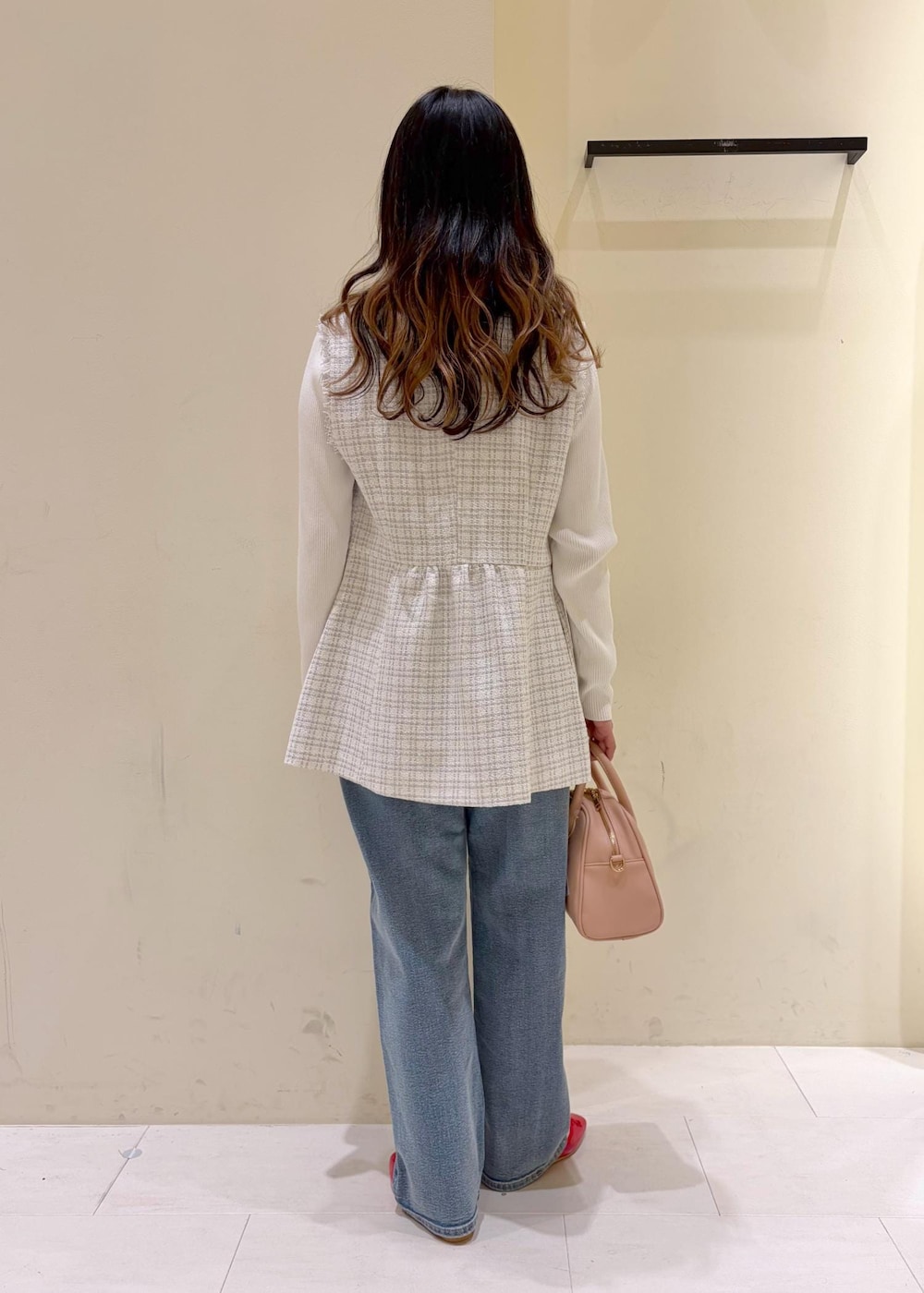 レッド系のバレエシューズ、ピンク系のボストンバッグ、ホワイト系のニット/セーターを着用したレディースの春コーディネートの3枚目の写真