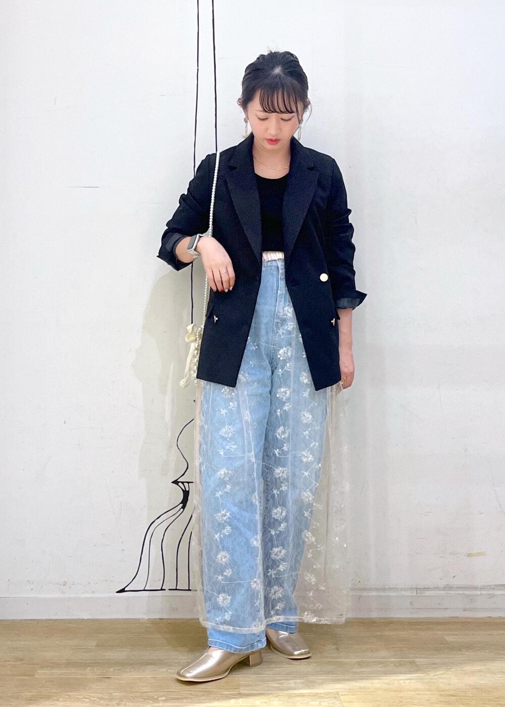 ホワイト系のスカート、ブラック系のニット/セーター、ブラック系のテーラードジャケットを着用したレディースの秋コーディネートの4枚目の写真