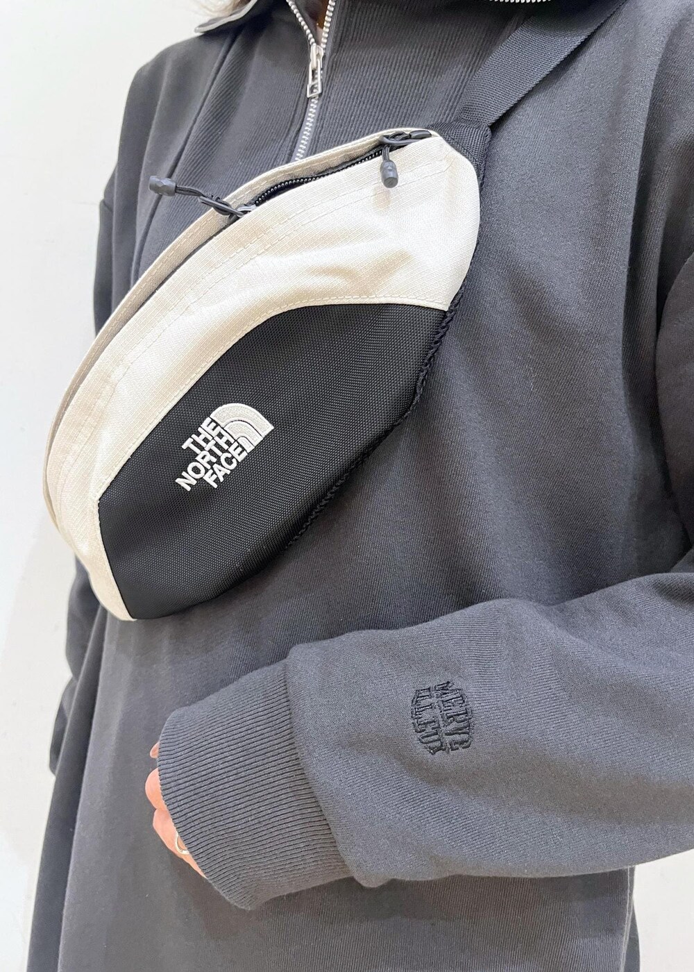 グリーン系のスカート、グレー系のワンピース、ホワイト系のボディバッグ/ウエストポーチを着用したレディースの秋コーディネートの7枚目の写真