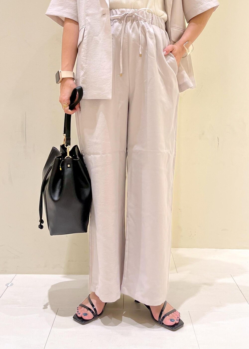 ベージュ系のタンクトップ、ベージュ系のその他パンツ、ベージュ系のテーラードジャケットを着用したレディースの夏コーディネートの8枚目の写真