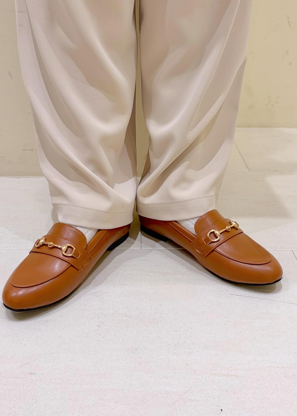 ホワイト系のTシャツ/カットソー、イエロー系のローファー、ベージュ系のボストンバッグを着用したレディースの冬コーディネートの10枚目の写真