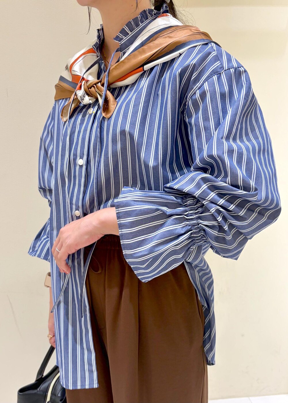 ブラウン系のその他パンツ、ブルー系のシャツ/ブラウス、ブラック系のローファーを着用したレディースの秋コーディネートの7枚目の写真