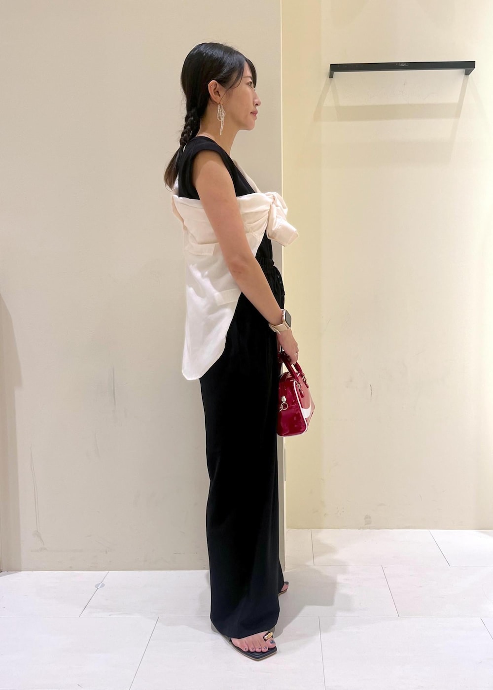 ブラック系のニット/セーター、ホワイト系のシャツ/ブラウス、ブラック系のサンダルを着用したレディースの夏コーディネートの3枚目の写真