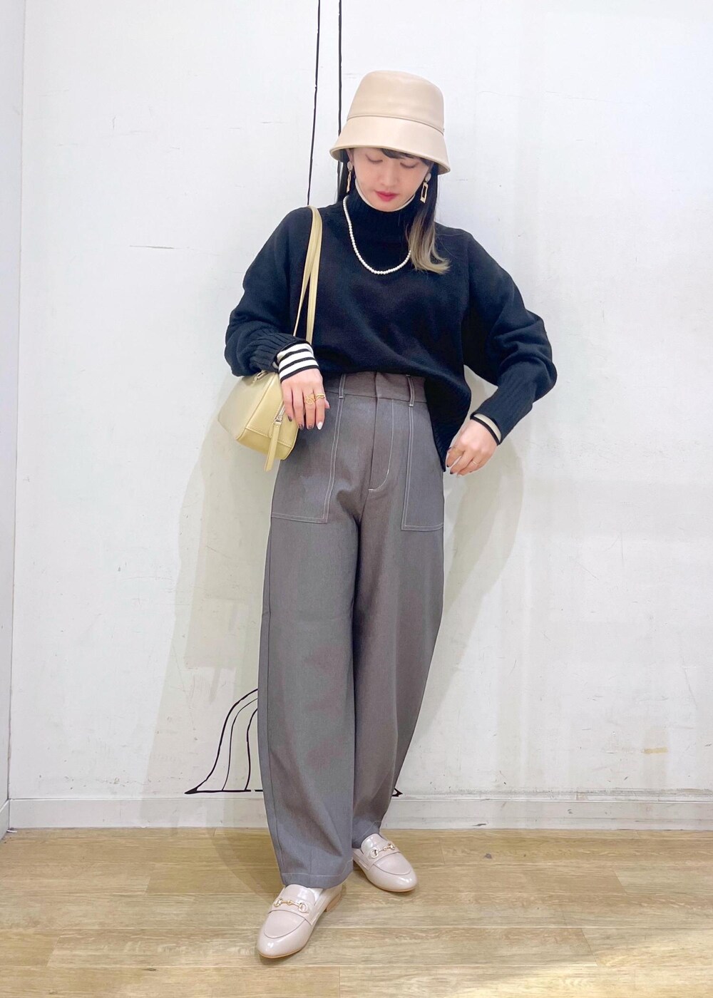 ベージュ系のローファー、ブラック系のニット/セーター、ホワイト系のニット/セーターを着用したレディースの冬コーディネートの2枚目の写真