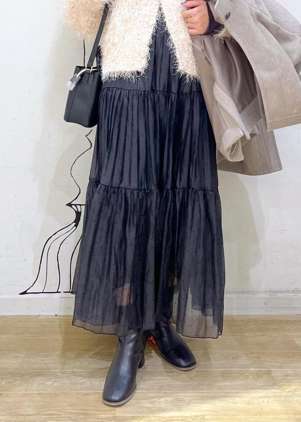 グレー系のTシャツ/カットソー、ベージュ系のカーディガン/ボレロ、ブラック系のブーツを着用したレディースの秋コーディネートの8枚目の写真