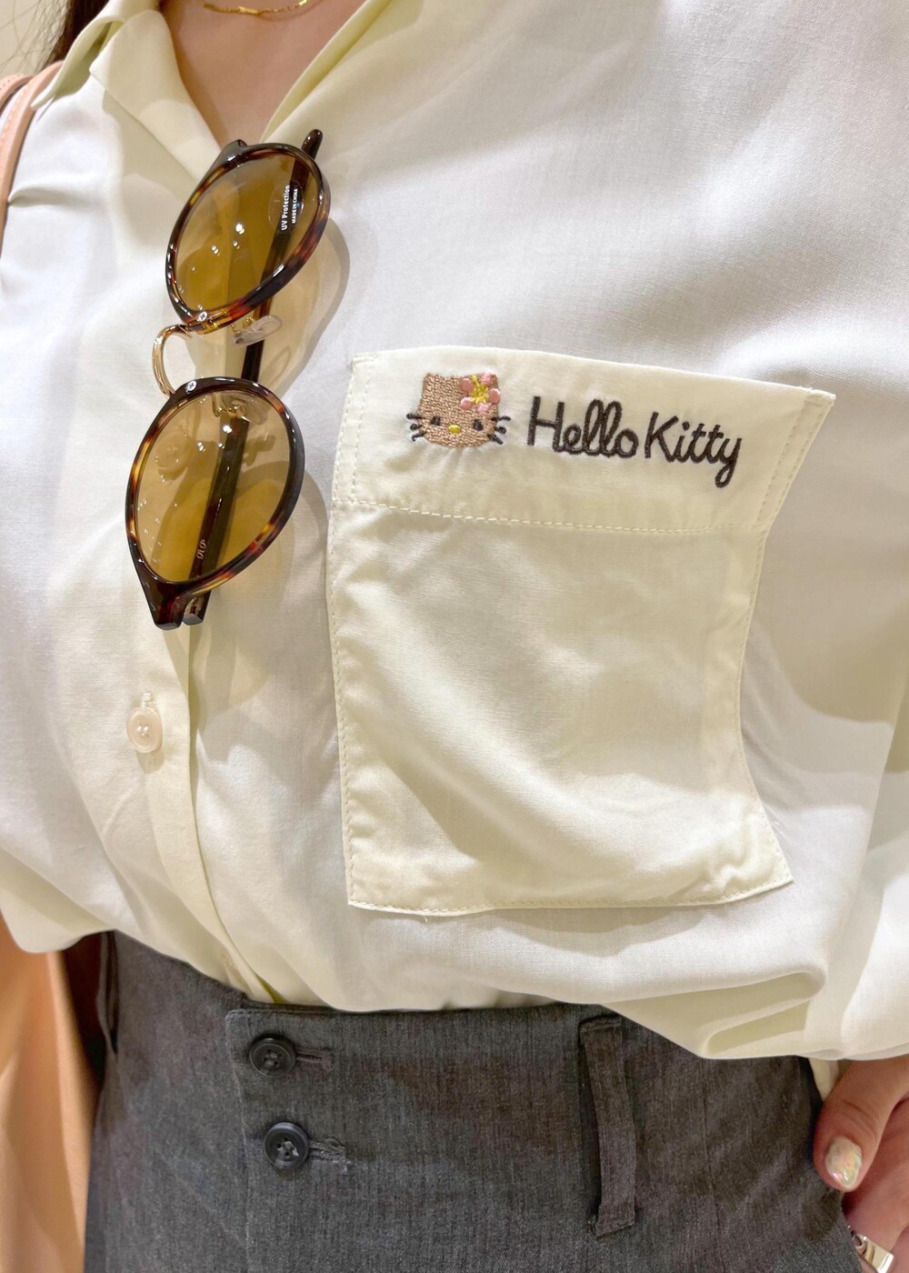 ピンク系のトートバッグ、グレー系のチノパンツ、ホワイト系のシャツ/ブラウスを着用したレディースの夏コーディネートの6枚目の写真