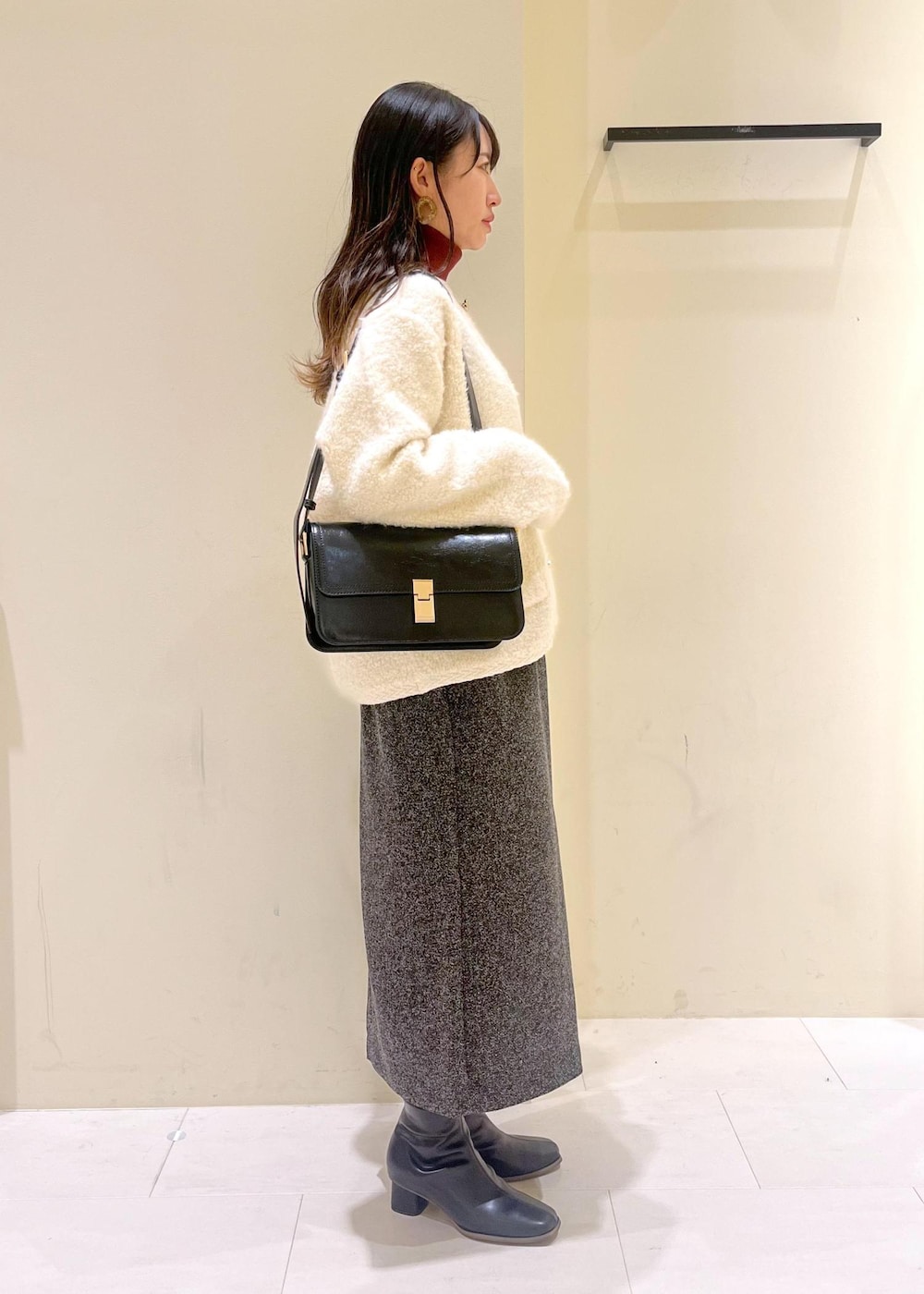 ブラック系のショルダーバッグ、ホワイト系のカーディガン/ボレロ、レッド系のニット/セーターを着用したレディースの秋コーディネートの2枚目の写真