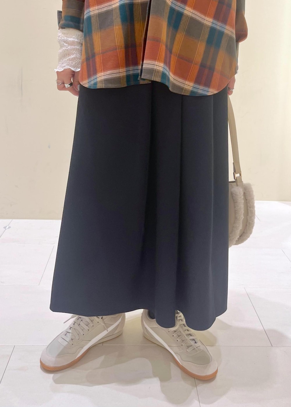 ブルー系のスカート、オレンジ系のシャツ/ブラウス、ホワイト系のTシャツ/カットソーを着用したレディースの秋コーディネートの8枚目の写真