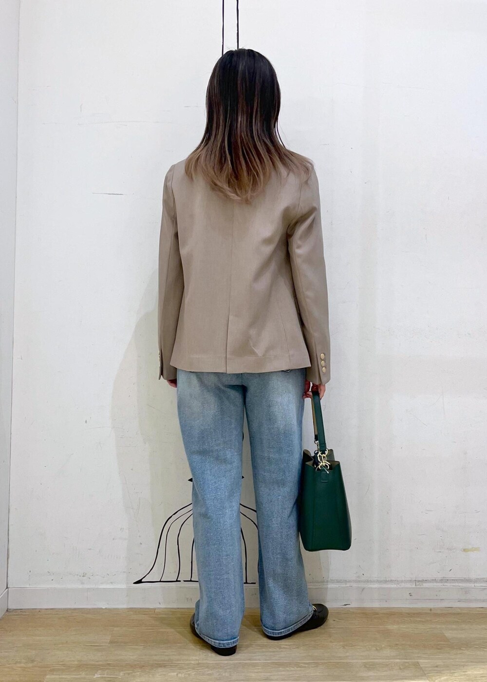 ホワイト系のニット/セーター、ブルー系のデニムパンツ、ブラック系のローファーを着用したレディースの冬コーディネートの4枚目の写真