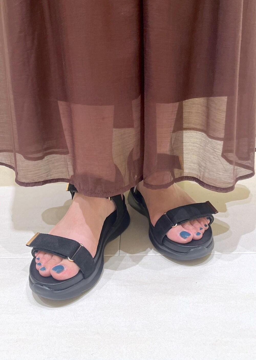 ブラック系のサンダル、ブラウン系のスカート、ベージュ系のベストを着用したレディースの夏コーディネートの10枚目の写真