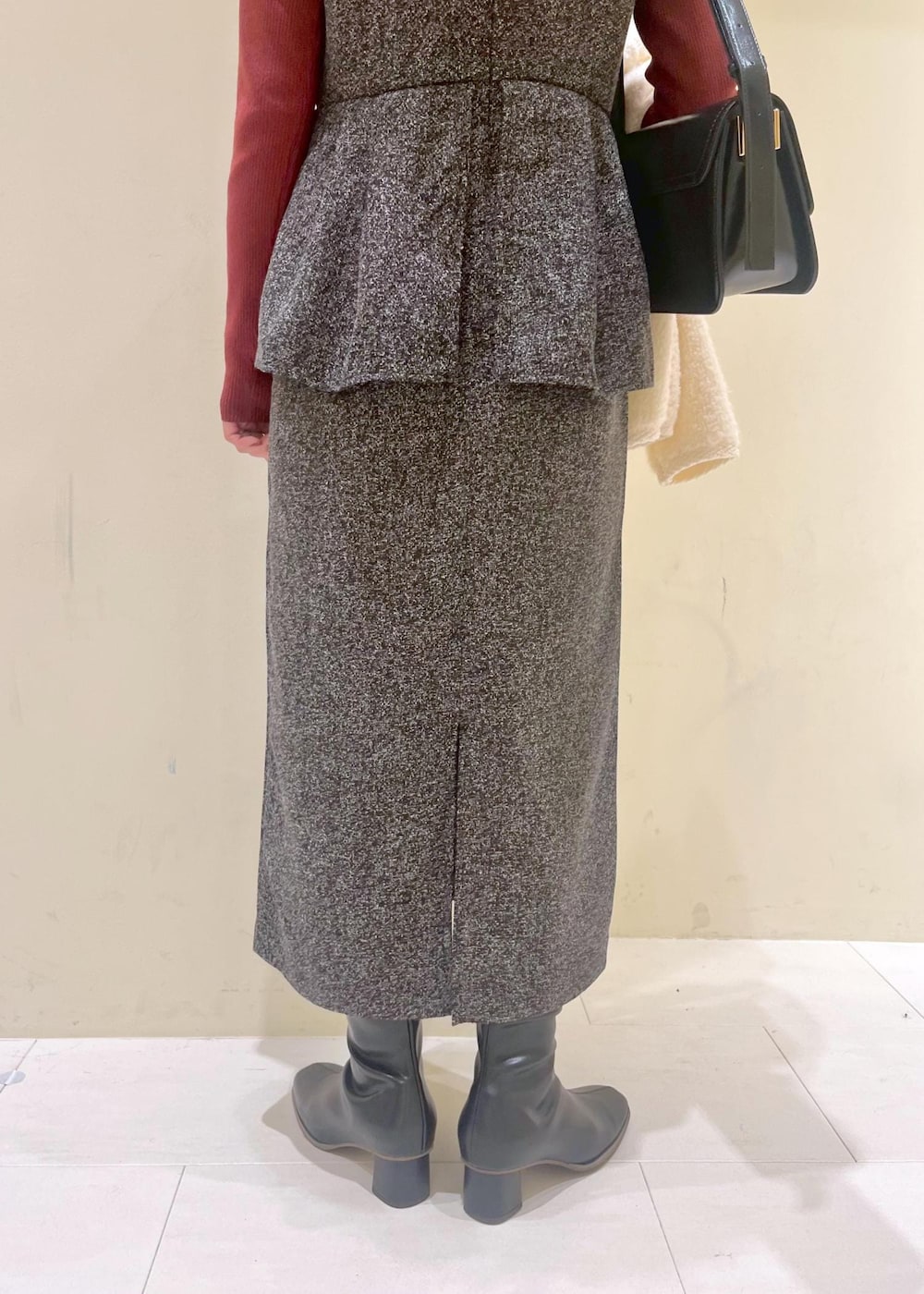 グレー系のジャンパースカート、ホワイト系のカーディガン/ボレロ、レッド系のニット/セーターを着用したレディースの冬コーディネートの6枚目の写真