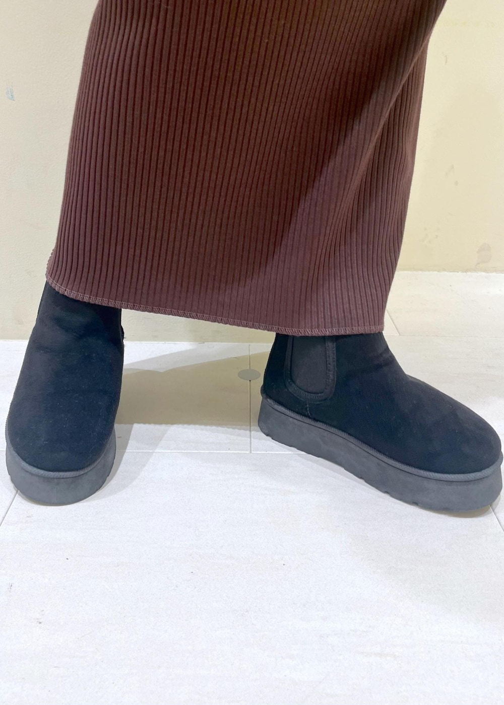 ブラック系のブーツ、ホワイト系のニット/セーター、シルバー系のハンドバッグを着用したレディースの冬コーディネートの10枚目の写真