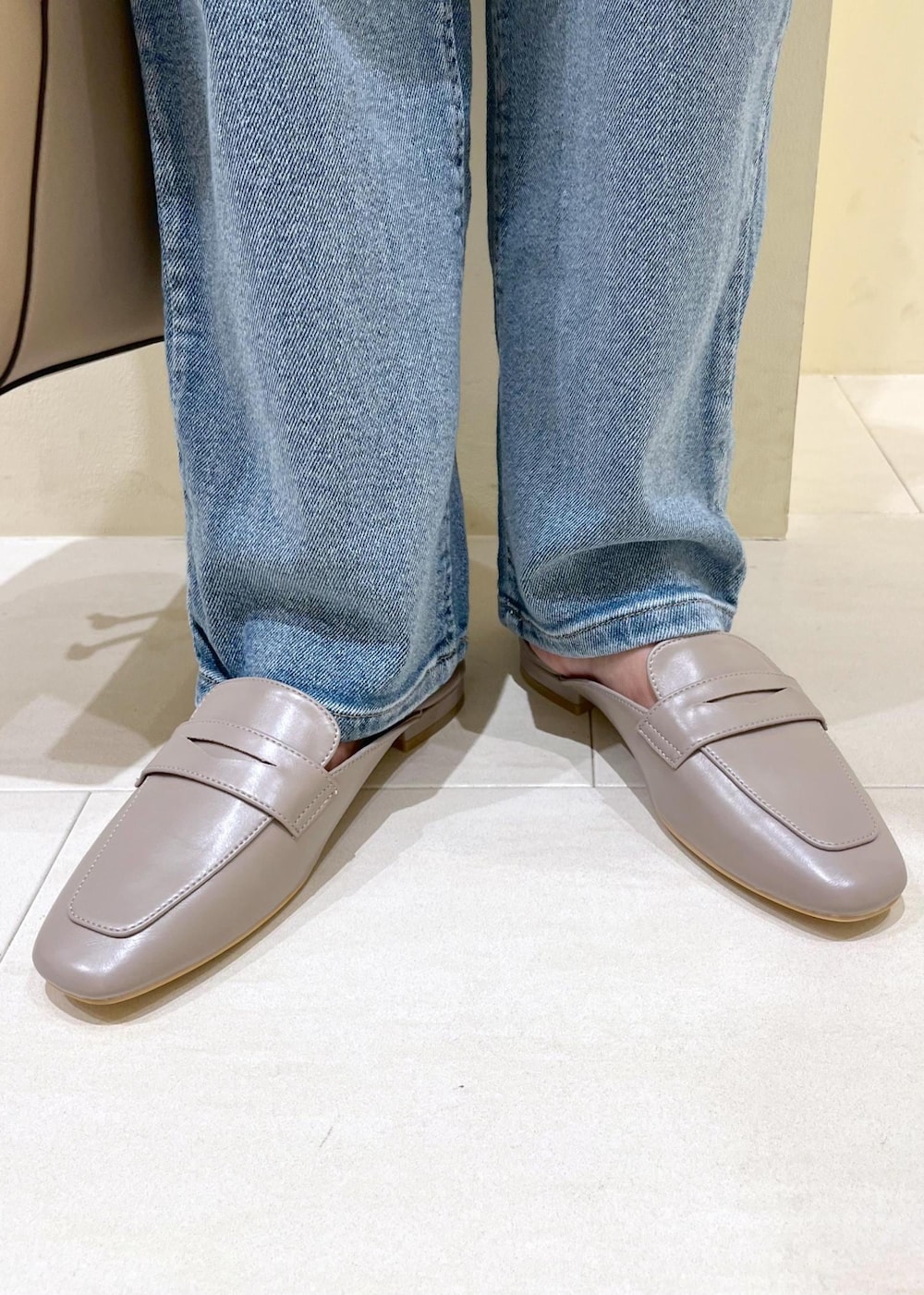 グレー系のローファー、ブルー系のデニムパンツ、ベージュ系のショルダーバッグを着用したレディースの夏コーディネートの10枚目の写真