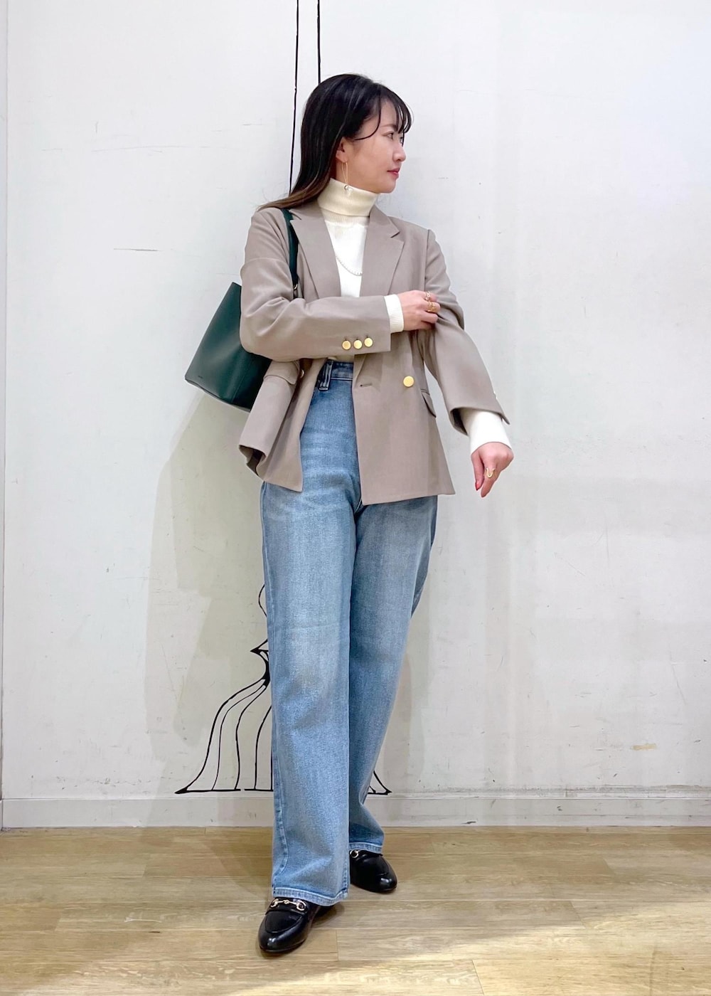 ホワイト系のニット/セーター、ブルー系のデニムパンツ、ブラック系のローファーを着用したレディースの冬コーディネートの2枚目の写真