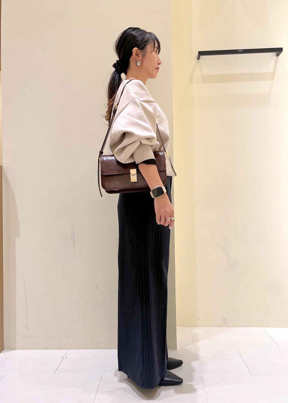 レッド系のショルダーバッグ、ブルー系のその他パンツ、ブラック系のTシャツ/カットソーを着用したレディースの秋コーディネートの2枚目の写真