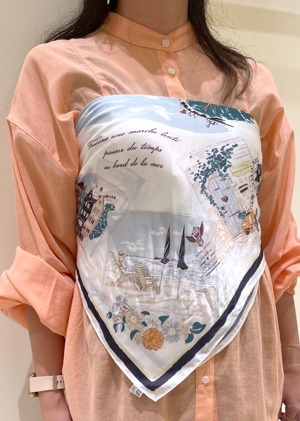 オレンジ系のシャツ/ブラウス、シルバー系のパンプス、ブラック系のトートバッグを着用したレディースの夏コーディネートの6枚目の写真