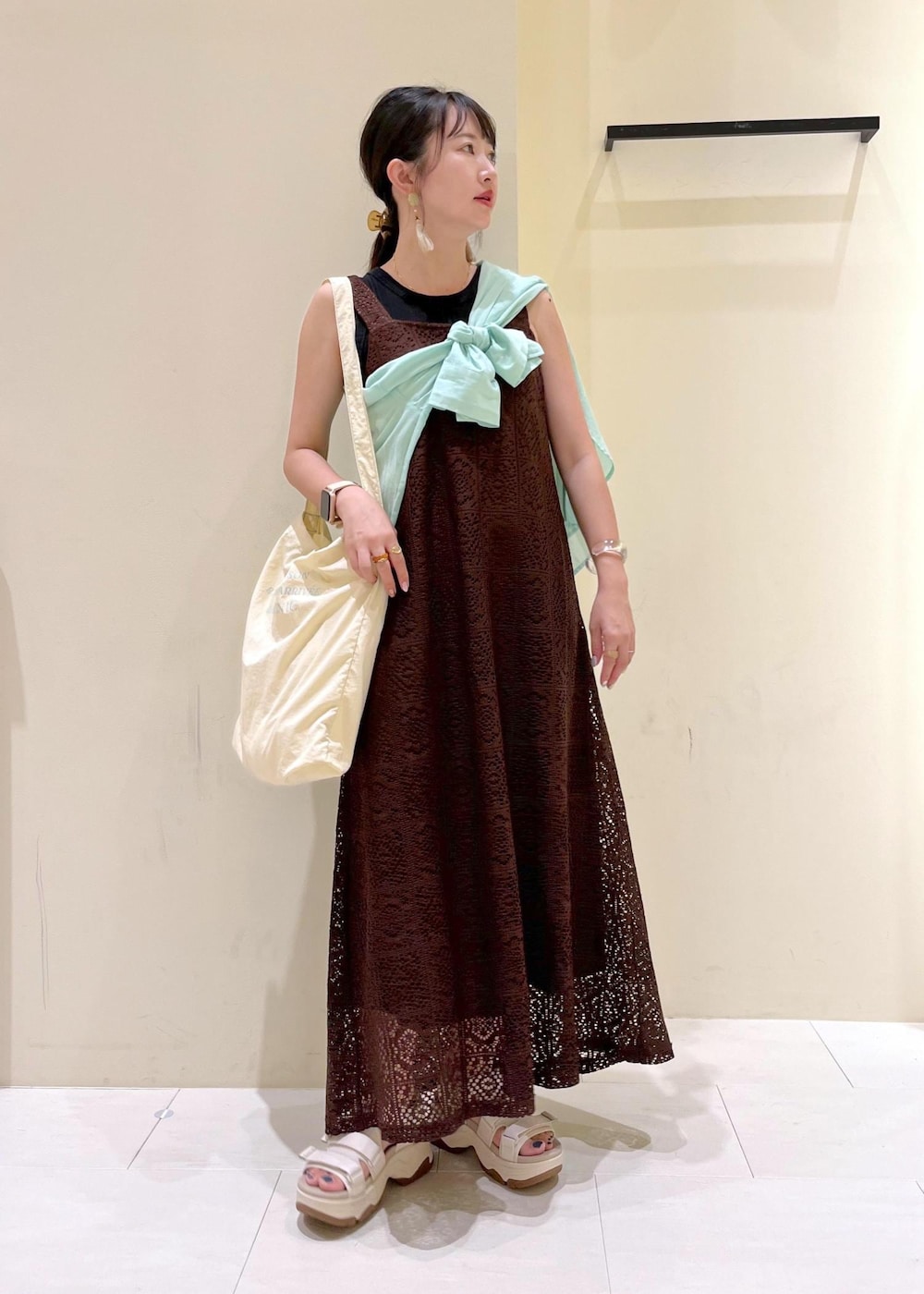 ブラック系のタンクトップ、グリーン系のシャツ/ブラウス、ホワイト系のトートバッグを着用したレディースの夏コーディネートの2枚目の写真