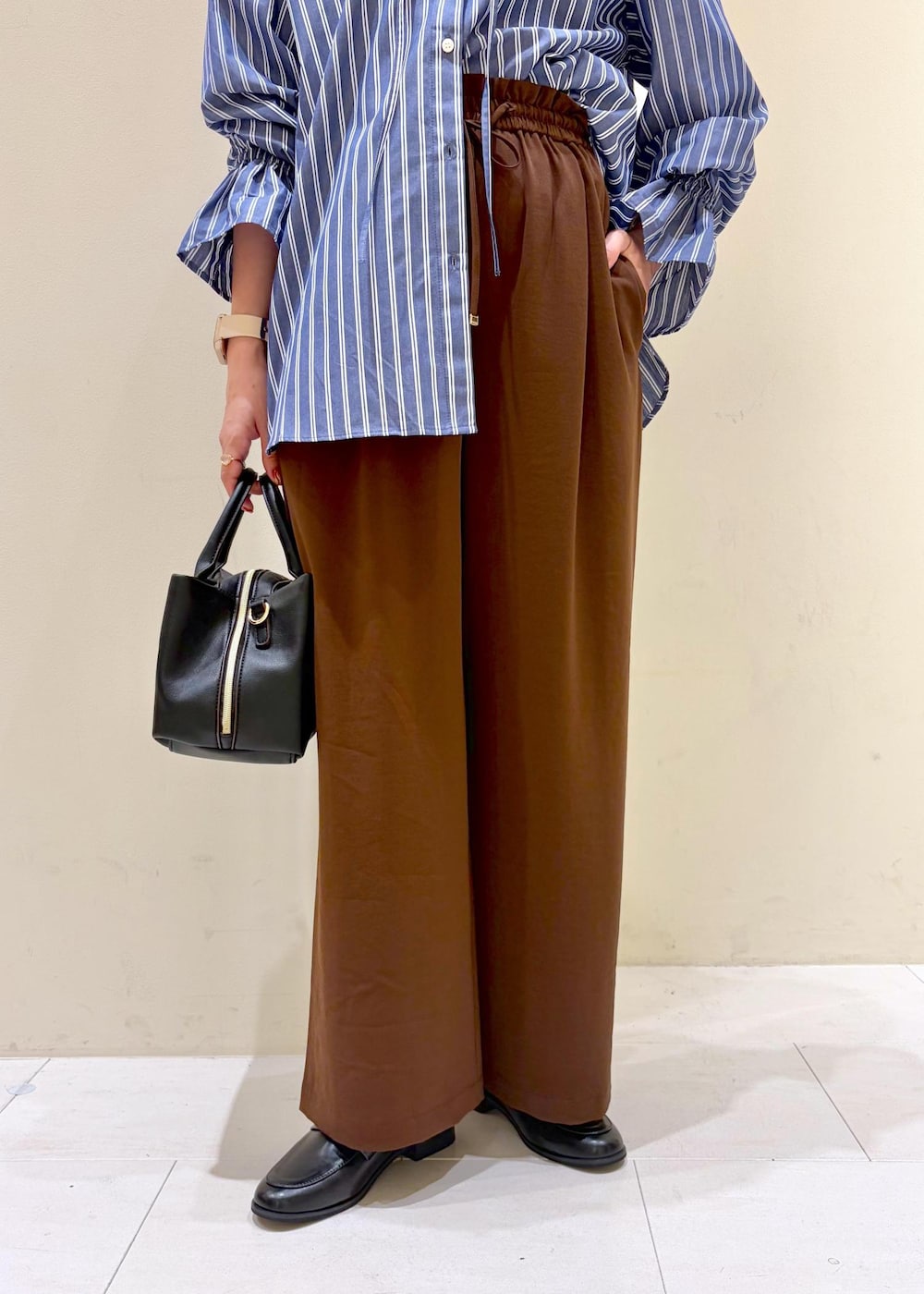 ブラウン系のその他パンツ、ブルー系のシャツ/ブラウス、ブラック系のローファーを着用したレディースの秋コーディネートの8枚目の写真