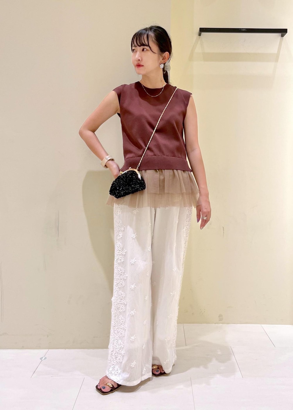 ブラック系のショルダーバッグ、ブラック系のサンダル、ホワイト系のその他パンツを着用したレディースの夏コーディネートの2枚目の写真