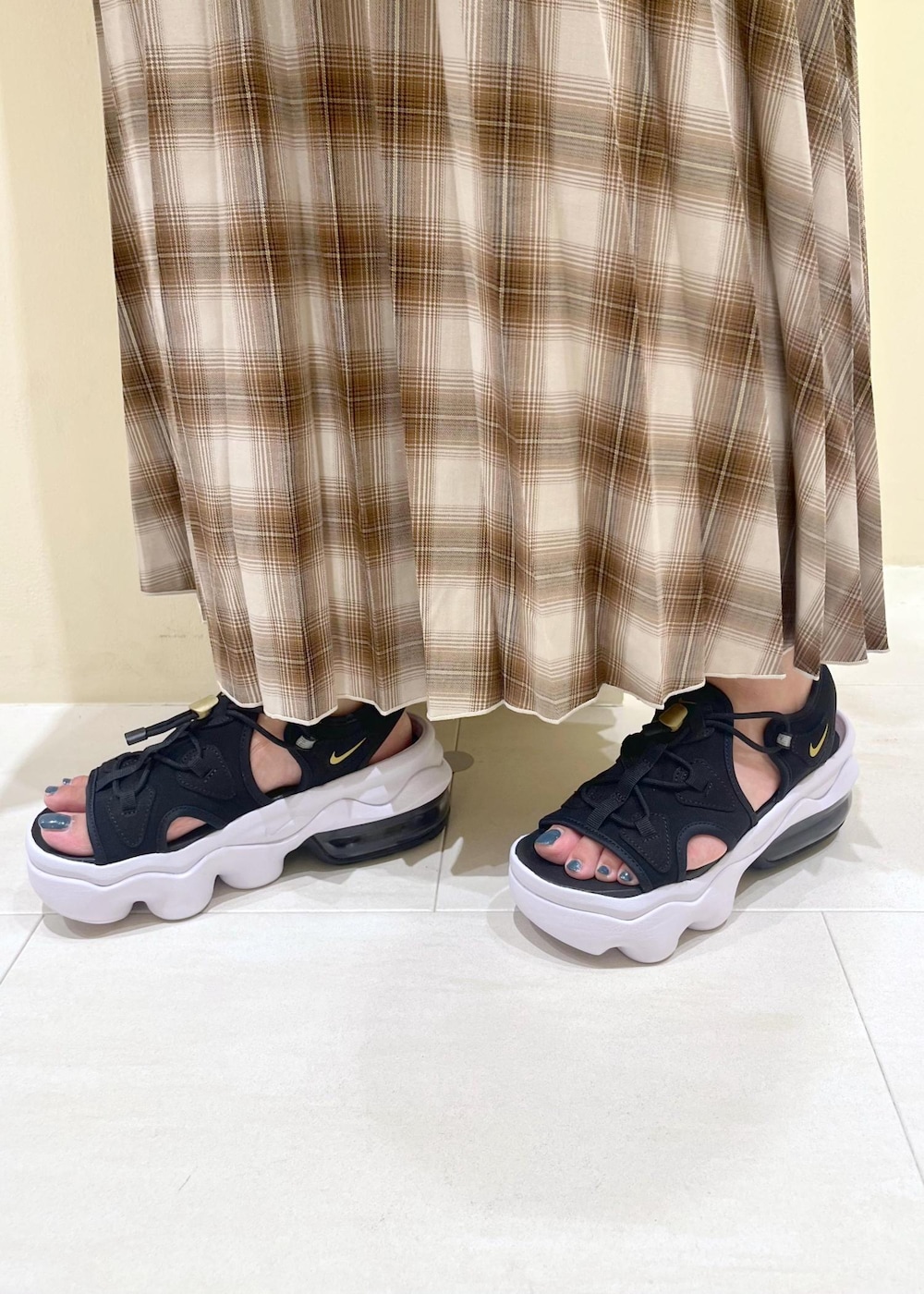 ホワイト系のシャツ/ブラウス、イエロー系のスカート、ブラック系のTシャツ/カットソーを着用したレディースの夏コーディネートの9枚目の写真