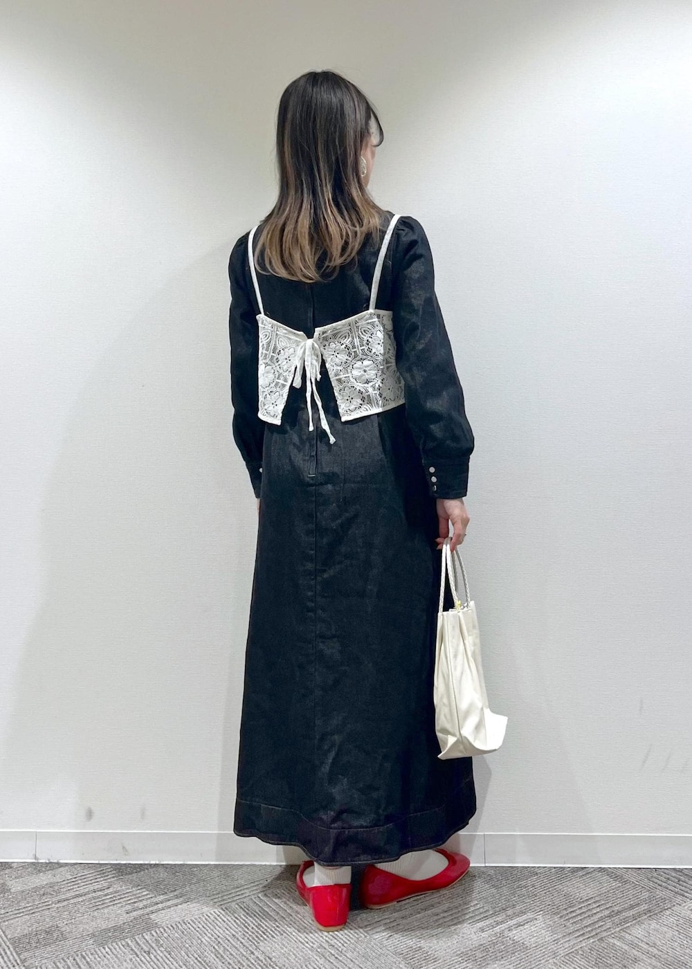 ホワイト系のトートバッグ、ホワイト系のキャミソール、レッド系のバレエシューズを着用したレディースの冬コーディネートの4枚目の写真