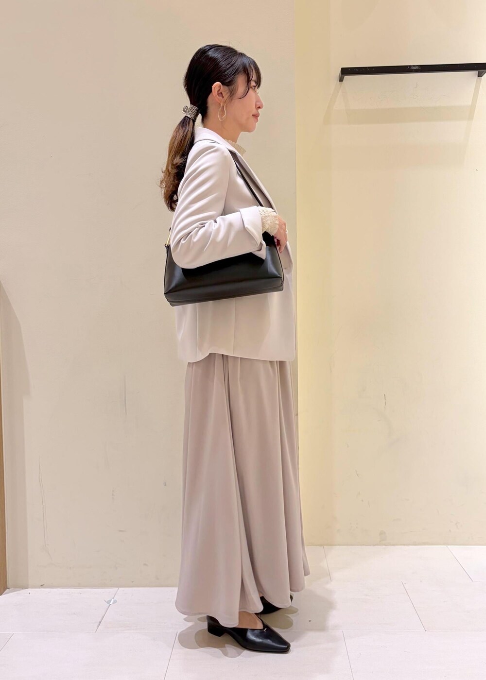 ベージュ系のその他パンツ、ブラック系のショルダーバッグ、グレー系のテーラードジャケットを着用したレディースの冬コーディネートの2枚目の写真