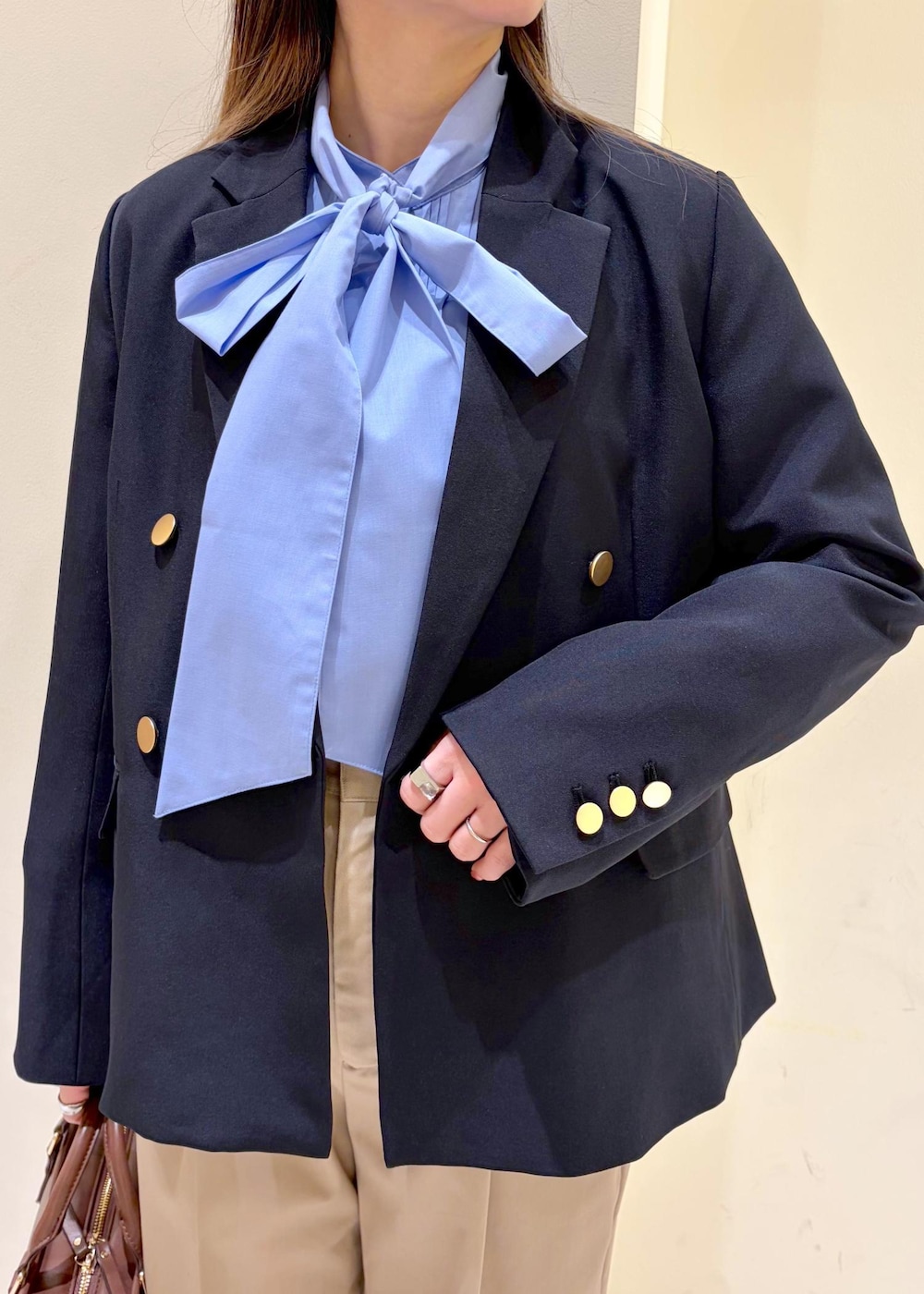 ブラック系のローファー、ブラウン系のボストンバッグ、ブルー系のテーラードジャケットを着用したレディースの冬コーディネートの5枚目の写真