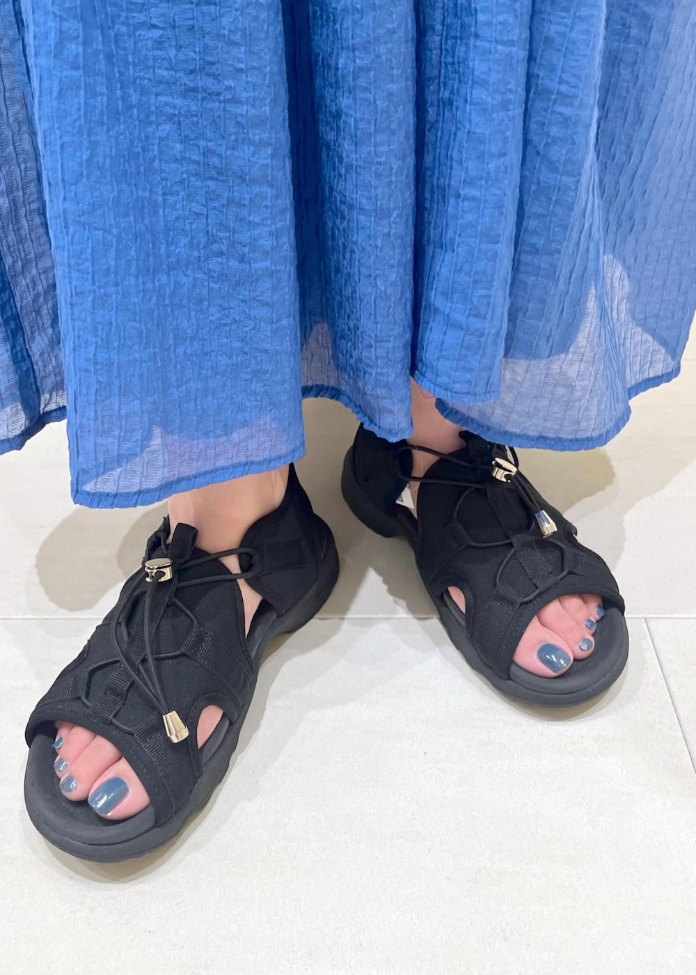 ブラック系のサンダル、ブラック系のバックパック/リュック、ブラック系のタンクトップを着用したレディースの春コーディネートの9枚目の写真