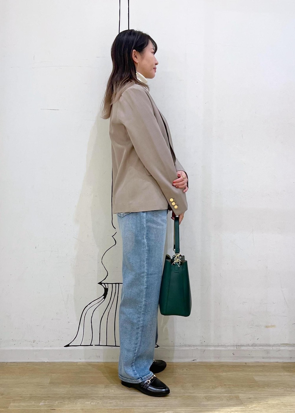 ホワイト系のニット/セーター、ブルー系のデニムパンツ、ブラック系のローファーを着用したレディースの冬コーディネートの3枚目の写真