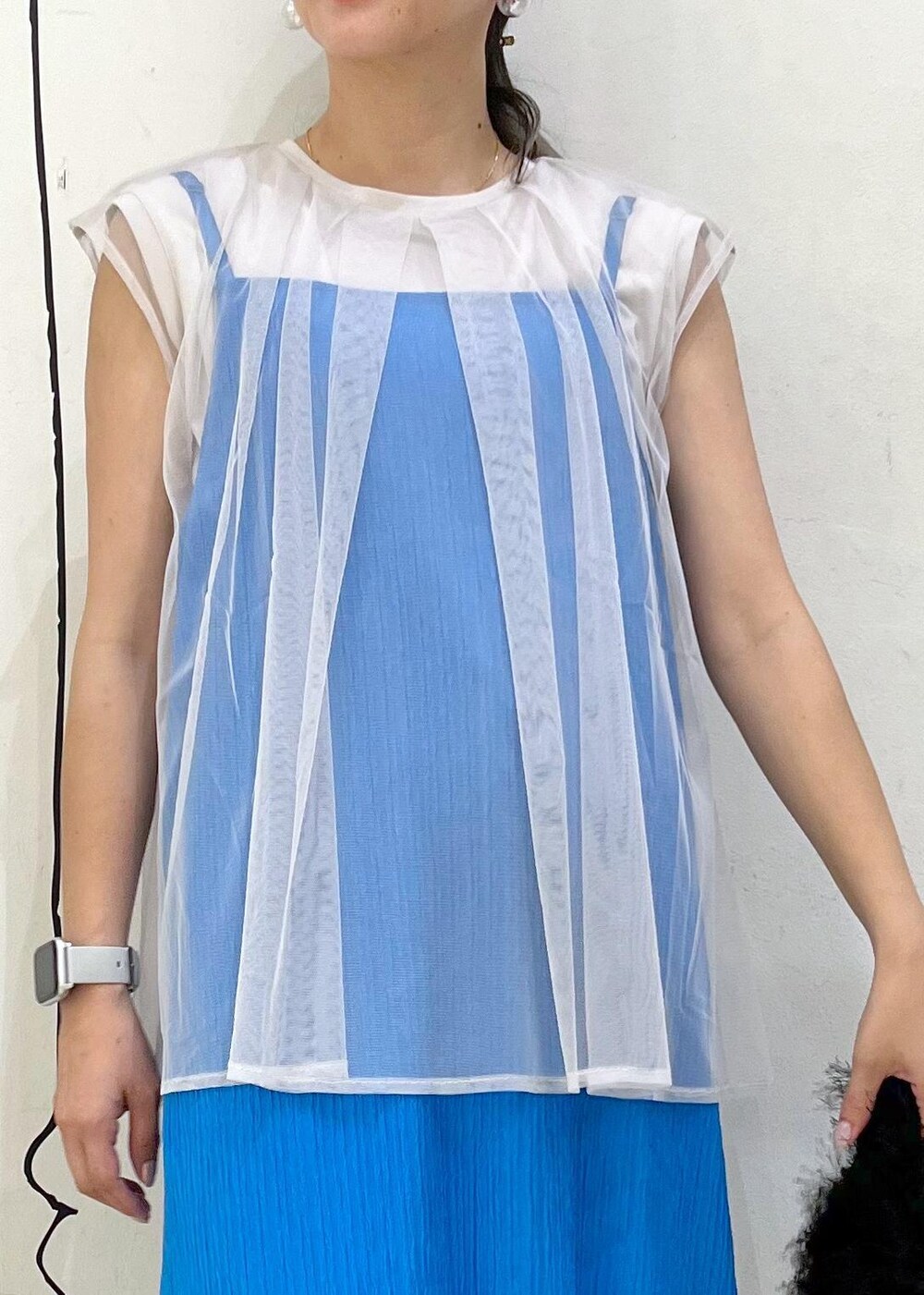 ホワイト系のサンダル、ブルー系のワンピース、ブラック系のハンドバッグを着用したレディースの夏コーディネートの4枚目の写真