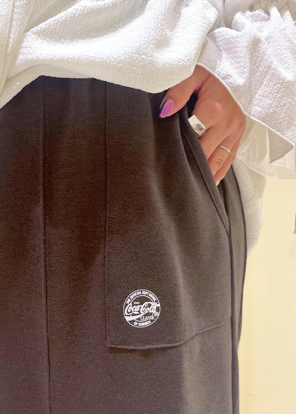 ピンク系のトートバッグ、ブラウン系のサンダル、ホワイト系のシャツ/ブラウスを着用したレディースの夏コーディネートの9枚目の写真