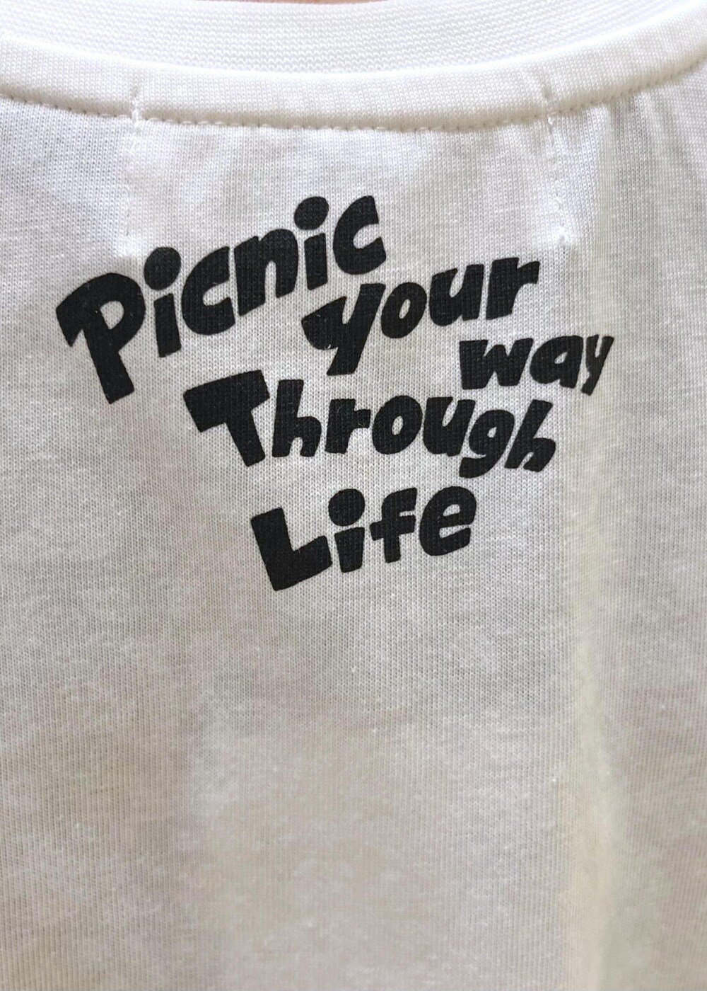 ブラック系のTシャツ/カットソー、ホワイト系のサンダル、ベージュ系のバックパック/リュックを着用したレディースの夏コーディネートの7枚目の写真