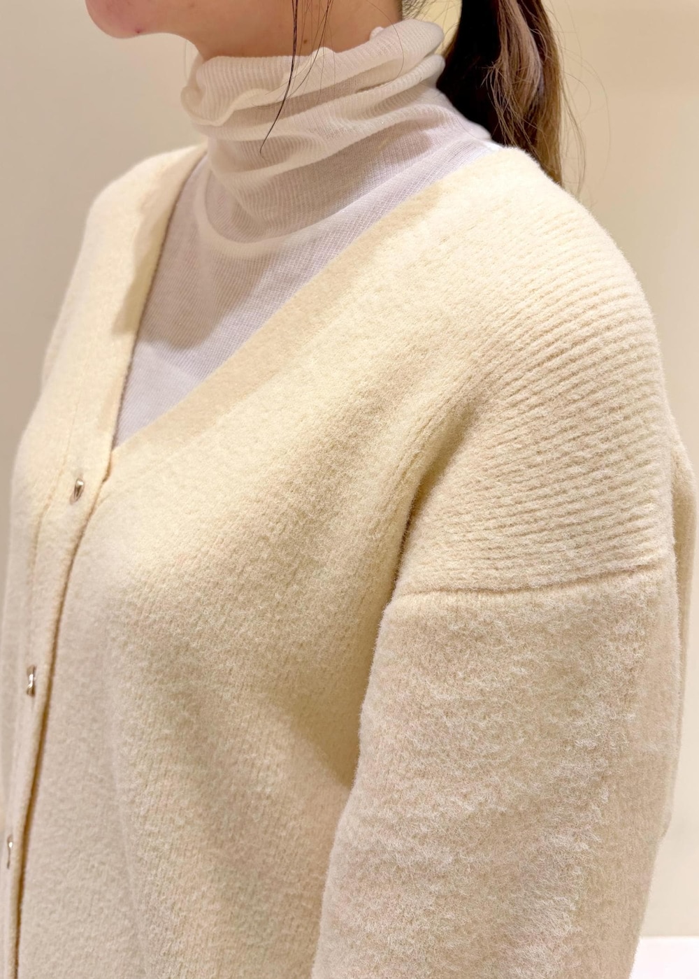 ベージュ系のカーディガン/ボレロ、ホワイト系のトートバッグ、ホワイト系のTシャツ/カットソーを着用したレディースの冬コーディネートの6枚目の写真