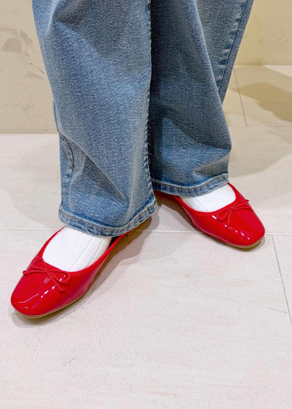 レッド系のバレエシューズ、ピンク系のボストンバッグ、ホワイト系のニット/セーターを着用したレディースの春コーディネートの10枚目の写真