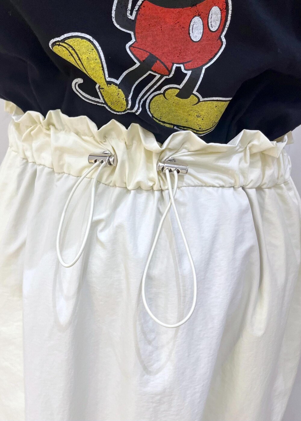 ホワイト系のスニーカー、グレー系のショルダーバッグ、ホワイト系のスカートを着用したレディースの夏コーディネートの7枚目の写真