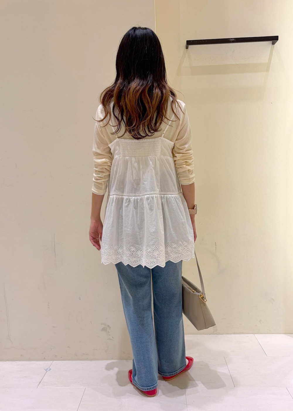 レッド系のバレエシューズ、ベージュ系のショルダーバッグ、ベージュ系のTシャツ/カットソーを着用したレディースの冬コーディネートの3枚目の写真