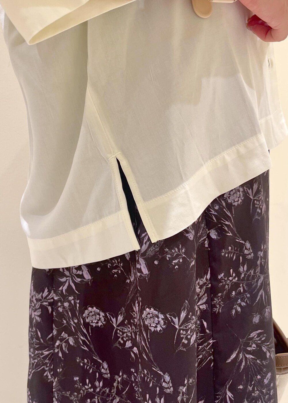 ブラウン系のトートバッグ、ゴールド系のサンダル、ブラック系のワンピースを着用したレディースの夏コーディネートの7枚目の写真