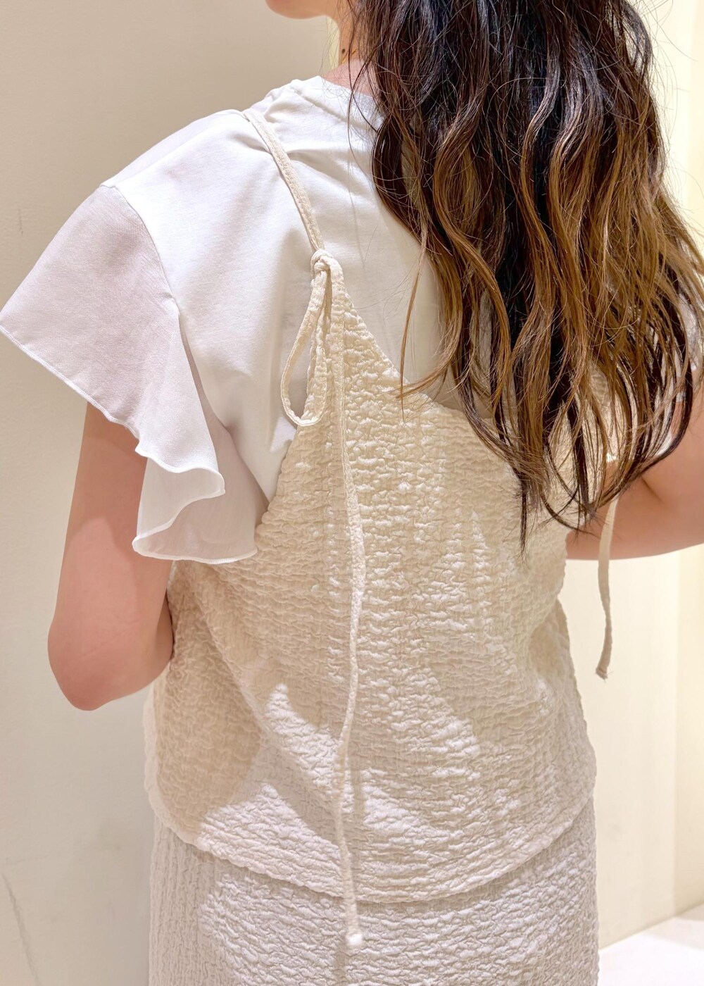 シルバー系のサンダル、シルバー系のトートバッグ、ホワイト系のTシャツ/カットソーを着用したレディースの夏コーディネートの7枚目の写真